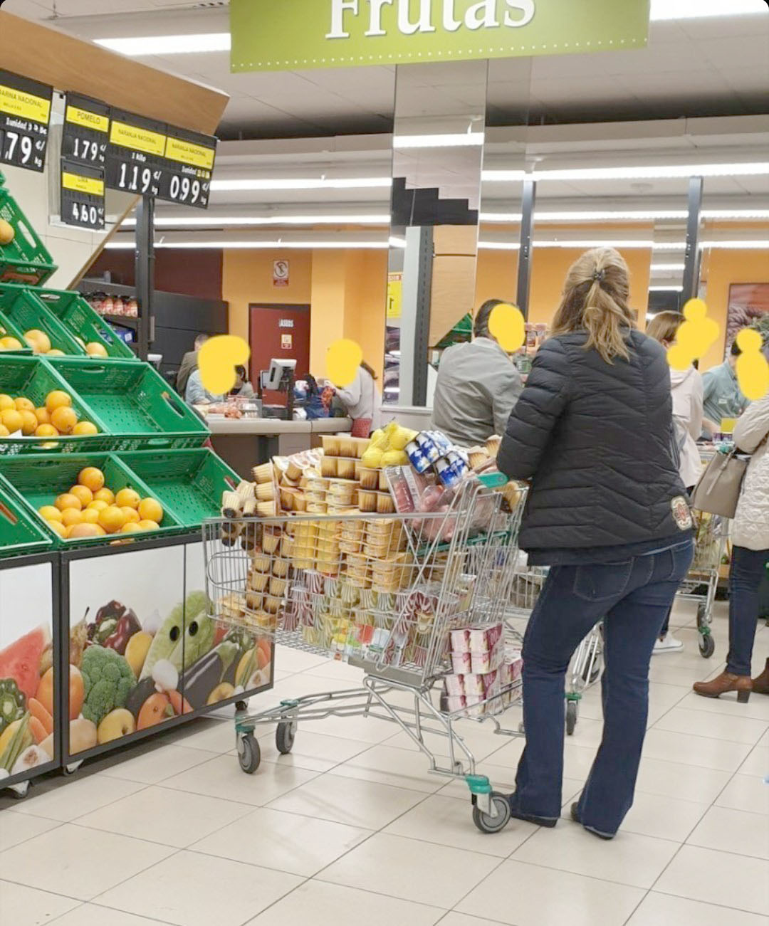 mujer en Mercadon con carro llego de flanes y yogures